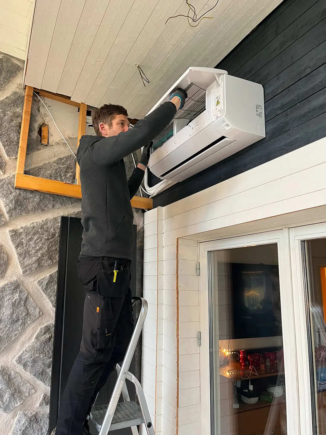 Certifierad tekniker från RC Kyl & Klimatteknik utför service på en luftvärmepumps innerdel
